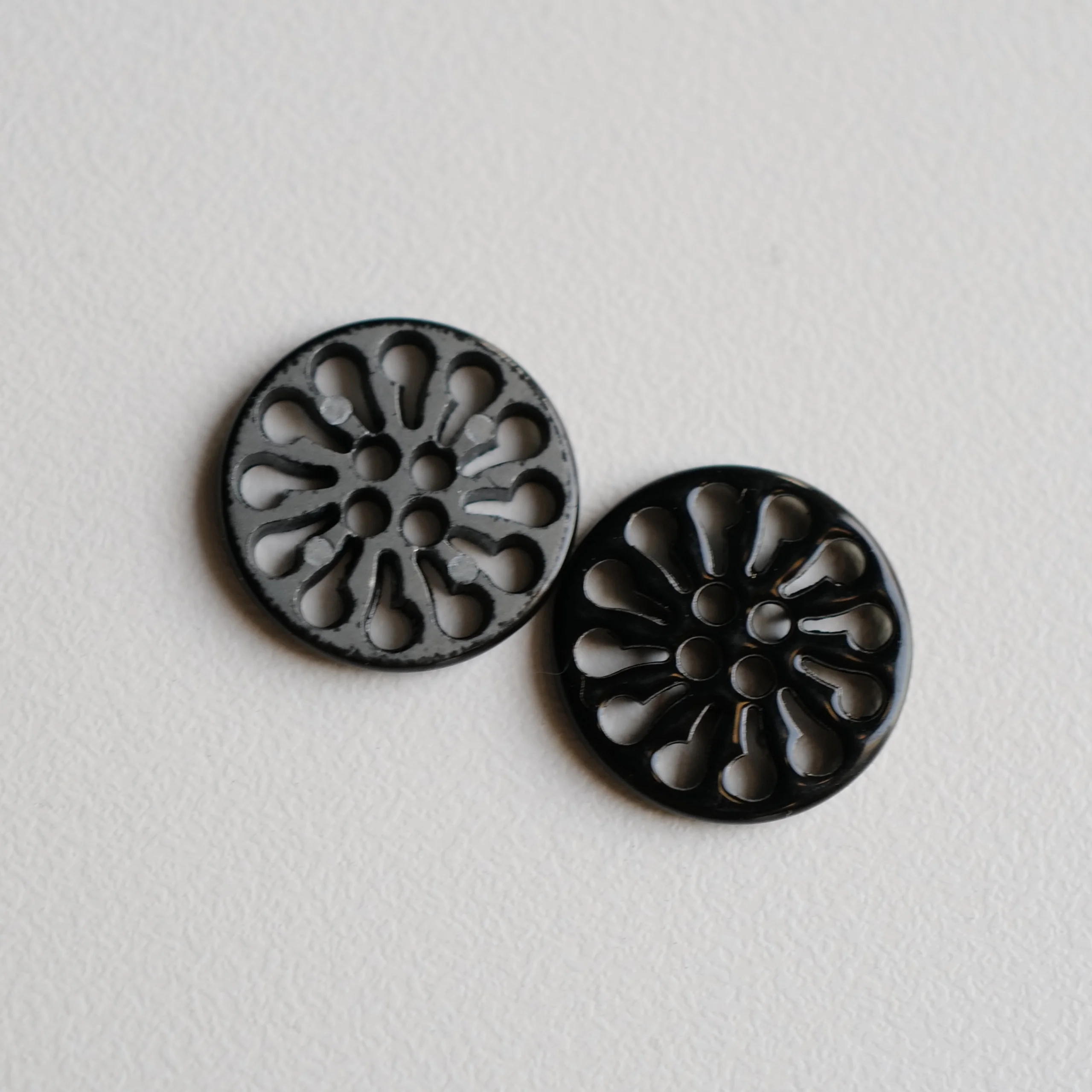 黒塗装の透かしデザイン金属ボタン【花輪形・ショート18mm】とは？