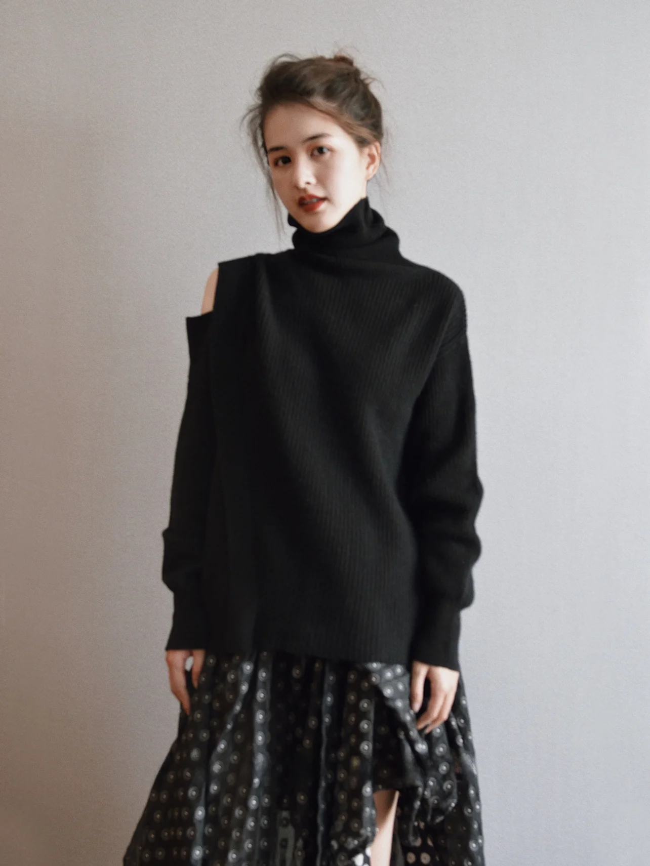 春コーデの基本アイテムとしての黒のハーフオフショルダー ハイネックニット