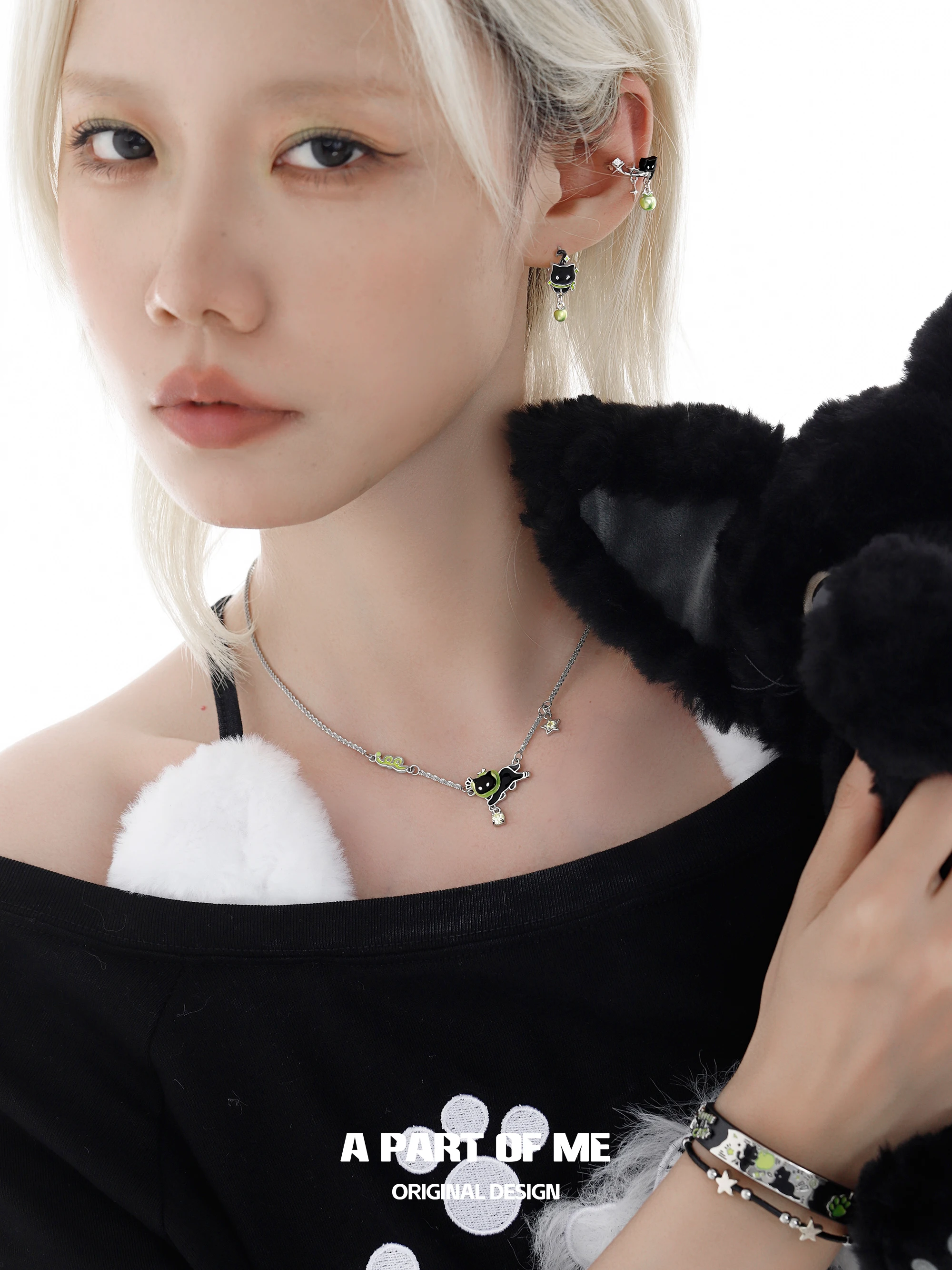 Y2Kスタイルに欠かせないアクセサリーは？黒猫と青リンゴの重ね付けネックレスが答えになる