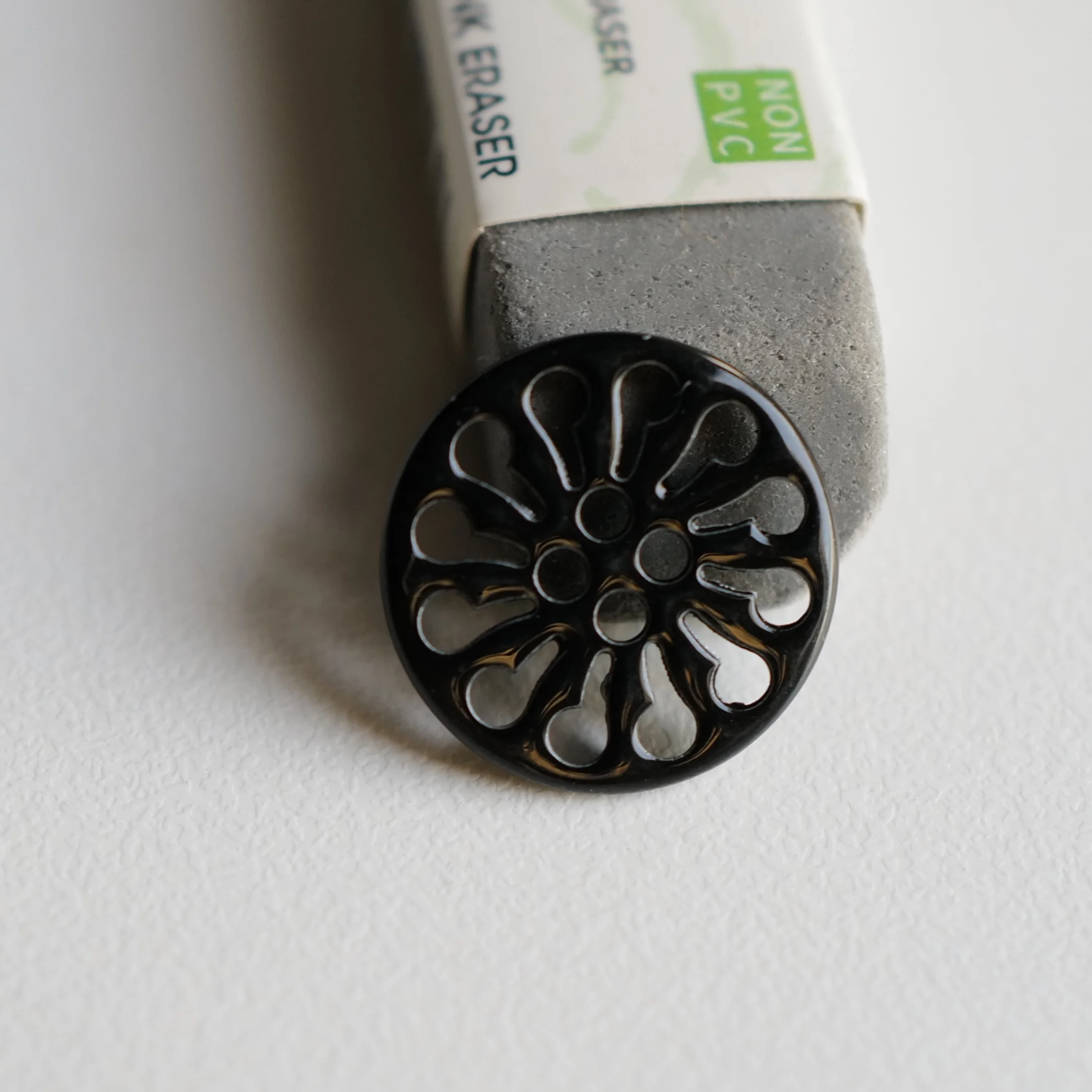 黒塗装の透かしデザイ  ン金属ボタン【花輪形・ショート18mm】とは？