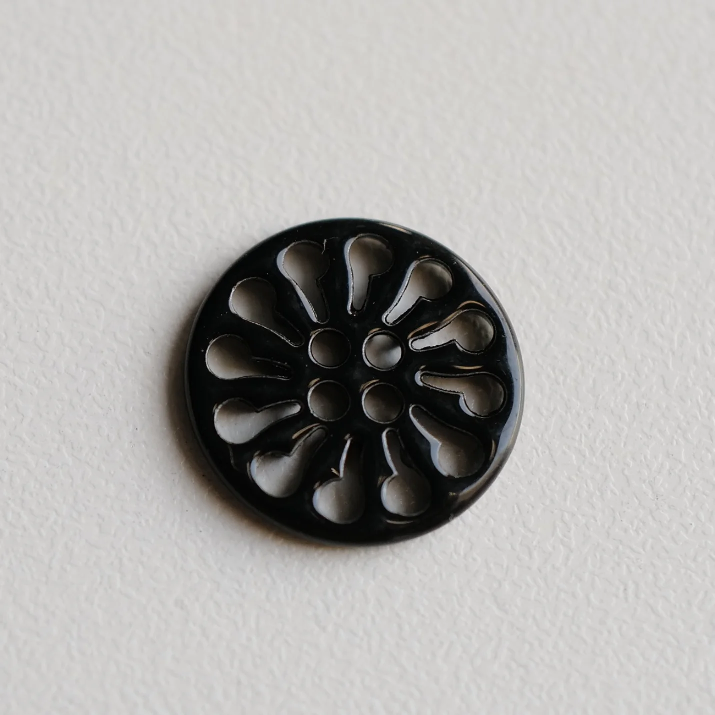 黒塗装の透かしデザイン金属ボタン【花輪形・ショート18mm】とは？