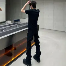 洗い加工された黒のフリンジ付きダメージデニムパンツ【スリムフィット・マイクロブーツカット】