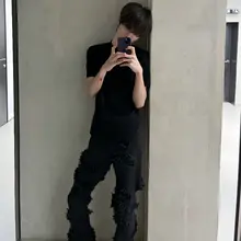 洗い加工された黒のフリンジ付きダメージデニムパンツ【スリムフィット・マイクロブーツカット】