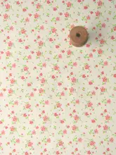 オフホワイトの底に青いバラの赤い花の束が入った竹綿と麻のベビー服