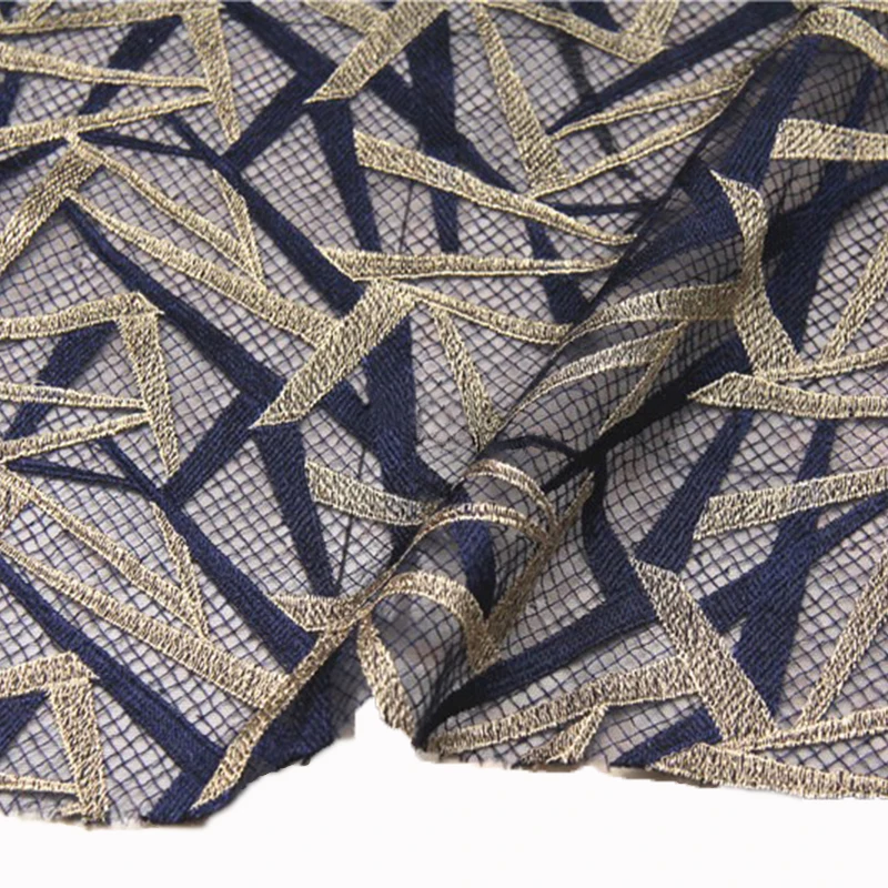 深い青と金の几何学模様の刺繍チュール生地とは何か