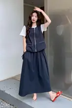 ダークブルーのカジュアルベストとスカート、白いTシャツの女性用コーディネート（セットアップ対応）