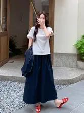 ダークブルーのカジュアルベストとスカート、白いTシャツの女性用コーディネート（セットアップ対応）
