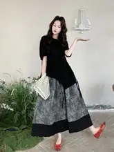 黒の透かし彫りベストとイレギュラーなカジュアルTシャツ