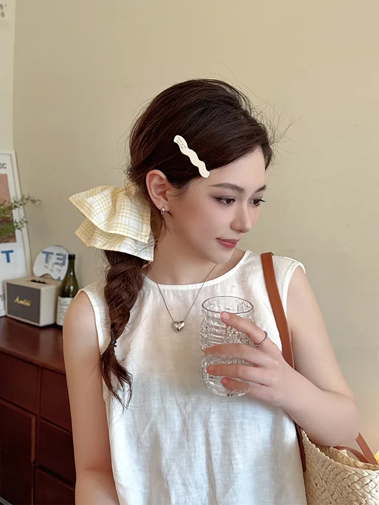 淡い黄色の格子柄ヘアゴム：フリル装飾で高級感を演出するポニーテールスタイル