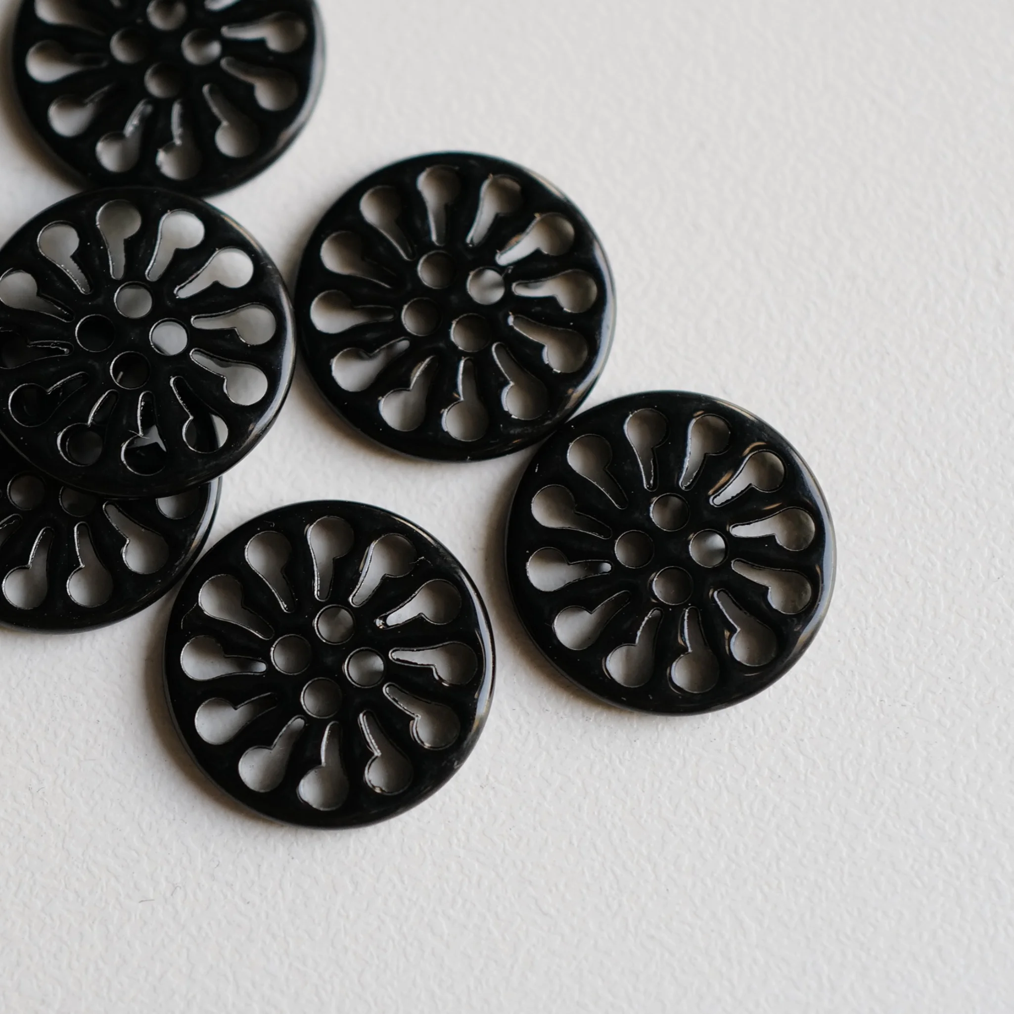 黒塗装の透かしデザイン金属ボタン【花輪形・ショート18mm】とは？