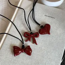 愛らしいリボンデザインのハートネックレス【長めの黒紐・お洒落なニットアクセサリー】