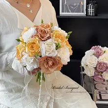 花嫁の手に持った花束、焦げた縁のバラの造花