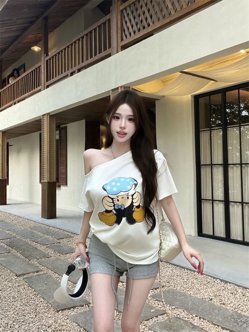 白色カートゥーンプリント斜め肩短袖Tシャツとハイウエストリボンショートパンツのセットアップ