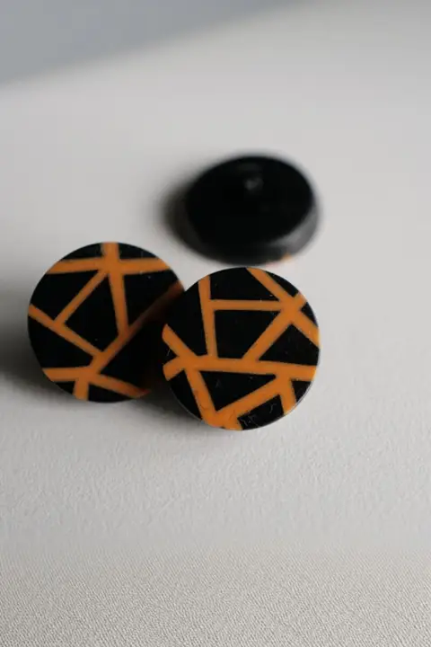 光沢のあるオレンジ色のネット模様ボタン【黒樹脂製・ドイツ製・20mm】