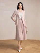 甘美なピーチピンクの七分袖ジャケットとプリーツスカートのファッションスタイル（セットアップ対応）