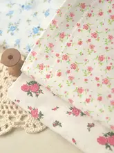 オフホワイトの底に青いバラの赤い花の束が入った竹綿と麻のベビー服