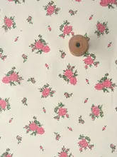 オフホワイトの底に青いバラの赤い花の束が入った竹綿と麻のベビー服